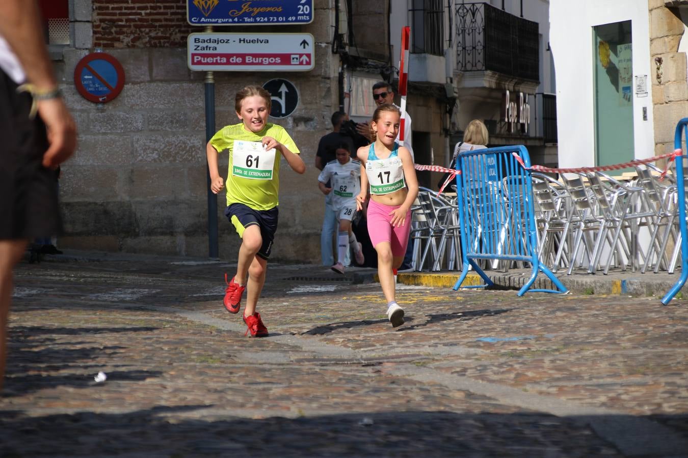 La Plaza de España de Jerez de los Caballeros acogió, ayer, la XXI Carrera Popular y VIII Caminata por la Salud y Solidaridad, organizada por la Concejalía de Juventud y Deportes del Ayuntamiento de Jerez con el apoyo del Programa de Dinamización Deportiva de la Mancomunidad Sierra Suroeste. Esta edición congregó a más de 250 participantes entre todas las categorías y se recaudaron 84 kilos de alimentos y 75 euros destinados a Cruz Roja en Jerez. La citada prueba se consagra, año tras año, como una de las citas deportivas ineludibles y más esperadas por los jerezanos y jerezanas. 