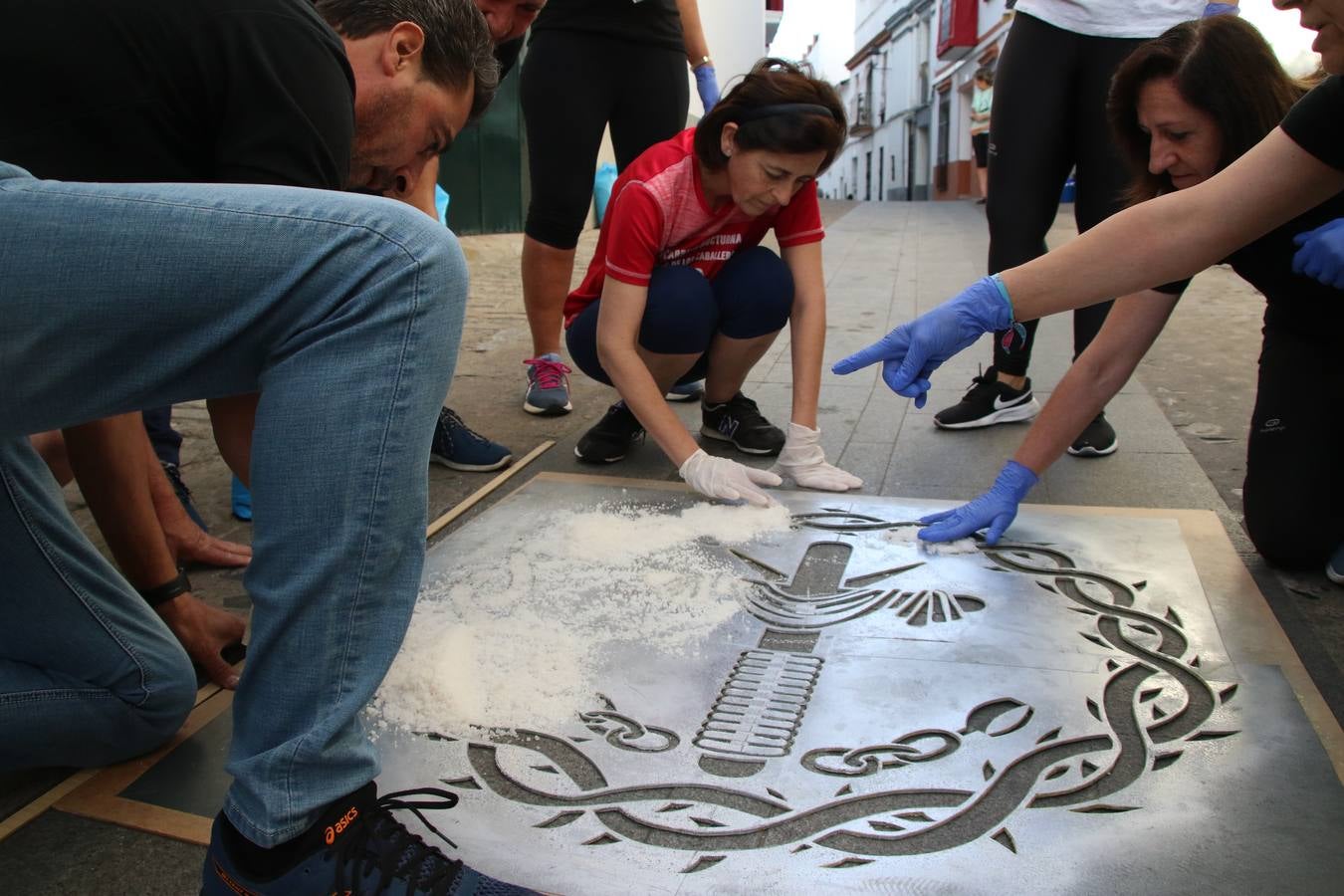 Las alfombras de sal embellecen y llenan de color, hoy, las calles de Jerez de los Caballeros con motivo de la festividad del Corpus Christi. Desde primera hora de la mañana, miembros de las cofradías y hermandades, Cáritas, grupos de catequesis, familias de los niños que han hecho este año la Primera Comunión, miembros de la Asociación de costaleros y costaleras de la Semana Santa jerezana, Ayuntamiento y vecinos han cubierto las principales calles del municipio con 6.250 kilos de sal teñida, plenas de color. A continuación, han disfrutado de una jornada de convivencia en la Casa de la Iglesia 'Cecilia de Arteaga'.