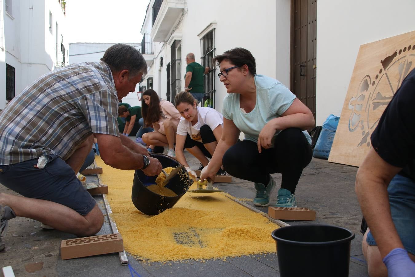 Las alfombras de sal embellecen y llenan de color, hoy, las calles de Jerez de los Caballeros con motivo de la festividad del Corpus Christi. Desde primera hora de la mañana, miembros de las cofradías y hermandades, Cáritas, grupos de catequesis, familias de los niños que han hecho este año la Primera Comunión, miembros de la Asociación de costaleros y costaleras de la Semana Santa jerezana, Ayuntamiento y vecinos han cubierto las principales calles del municipio con 6.250 kilos de sal teñida, plenas de color. A continuación, han disfrutado de una jornada de convivencia en la Casa de la Iglesia 'Cecilia de Arteaga'.
