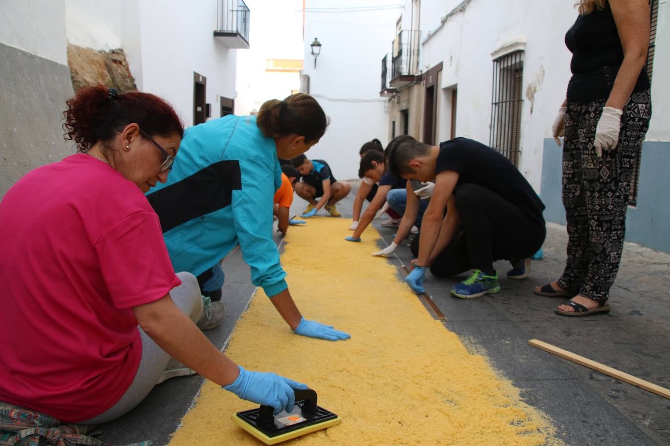 Las alfombras de sal embellecen y llenan de color, hoy, las calles de Jerez de los Caballeros con motivo de la festividad del Corpus Christi. Desde primera hora de la mañana, miembros de las cofradías y hermandades, Cáritas, grupos de catequesis, familias de los niños que han hecho este año la Primera Comunión, miembros de la Asociación de costaleros y costaleras de la Semana Santa jerezana, Ayuntamiento y vecinos han cubierto las principales calles del municipio con 6.250 kilos de sal teñida, plenas de color. A continuación, han disfrutado de una jornada de convivencia en la Casa de la Iglesia 'Cecilia de Arteaga'.