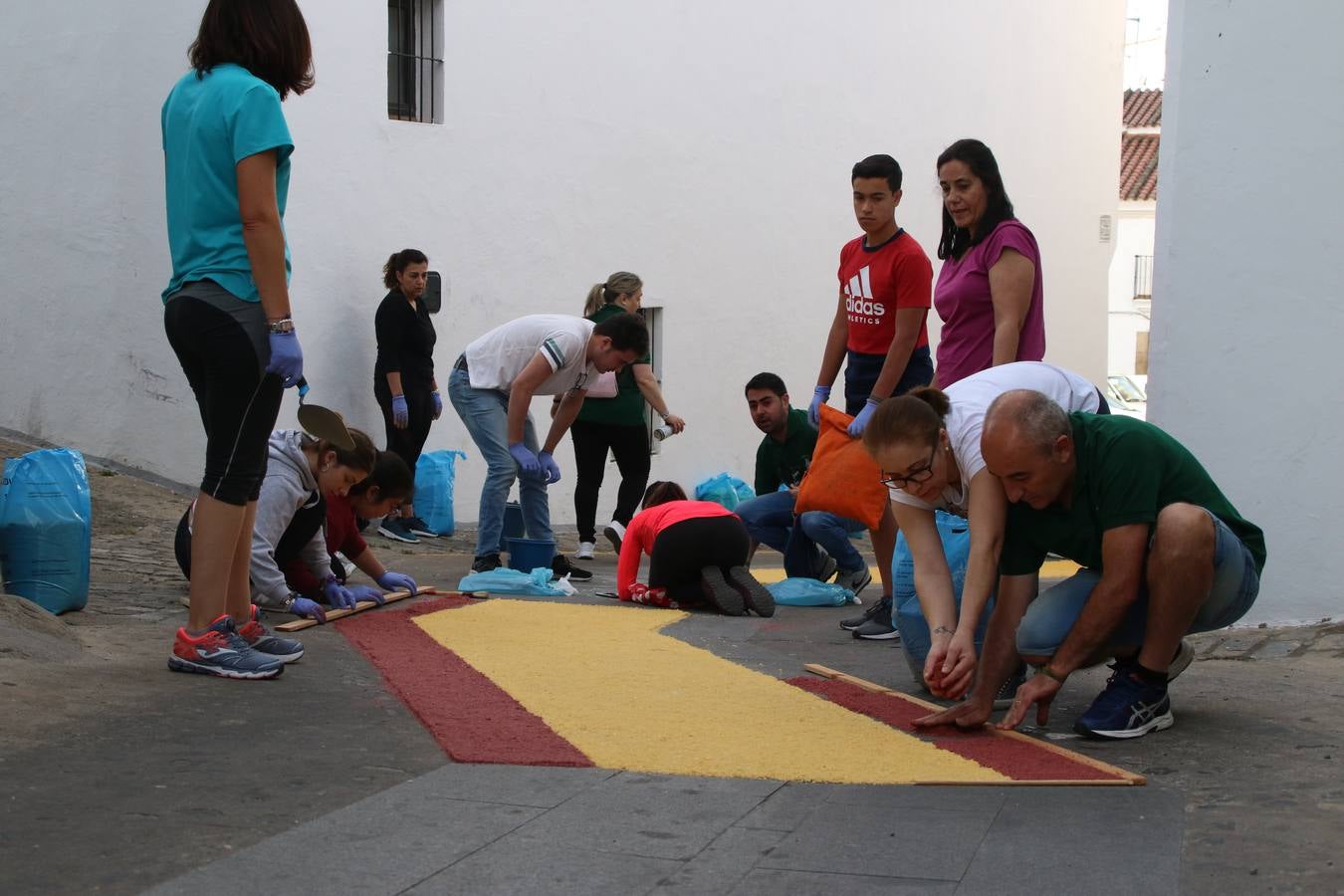 Las alfombras de sal embellecen y llenan de color, hoy, las calles de Jerez de los Caballeros con motivo de la festividad del Corpus Christi. Desde primera hora de la mañana, miembros de las cofradías y hermandades, Cáritas, grupos de catequesis, familias de los niños que han hecho este año la Primera Comunión, miembros de la Asociación de costaleros y costaleras de la Semana Santa jerezana, Ayuntamiento y vecinos han cubierto las principales calles del municipio con 6.250 kilos de sal teñida, plenas de color. A continuación, han disfrutado de una jornada de convivencia en la Casa de la Iglesia 'Cecilia de Arteaga'.