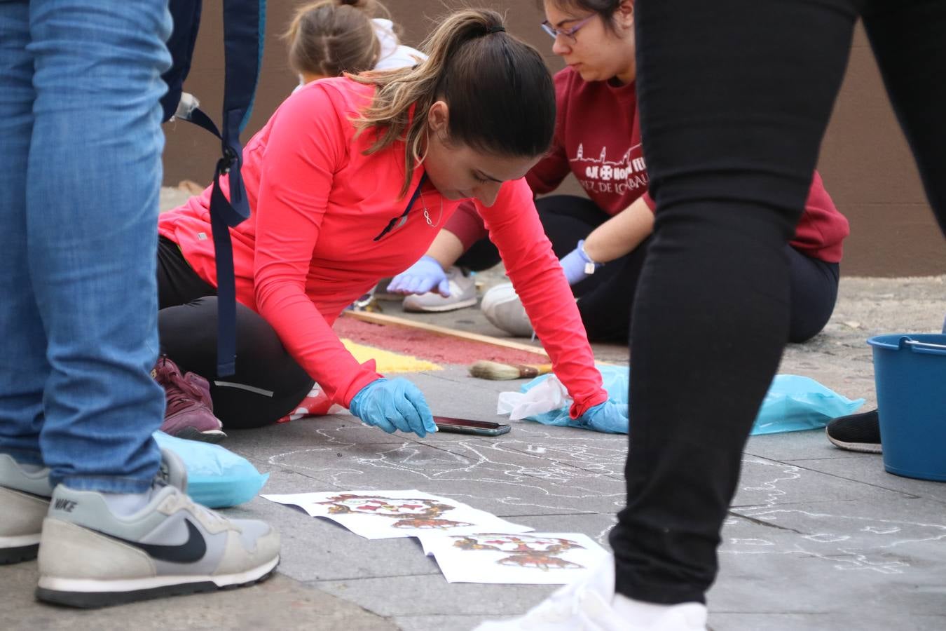 Las alfombras de sal embellecen y llenan de color, hoy, las calles de Jerez de los Caballeros con motivo de la festividad del Corpus Christi. Desde primera hora de la mañana, miembros de las cofradías y hermandades, Cáritas, grupos de catequesis, familias de los niños que han hecho este año la Primera Comunión, miembros de la Asociación de costaleros y costaleras de la Semana Santa jerezana, Ayuntamiento y vecinos han cubierto las principales calles del municipio con 6.250 kilos de sal teñida, plenas de color. A continuación, han disfrutado de una jornada de convivencia en la Casa de la Iglesia 'Cecilia de Arteaga'.