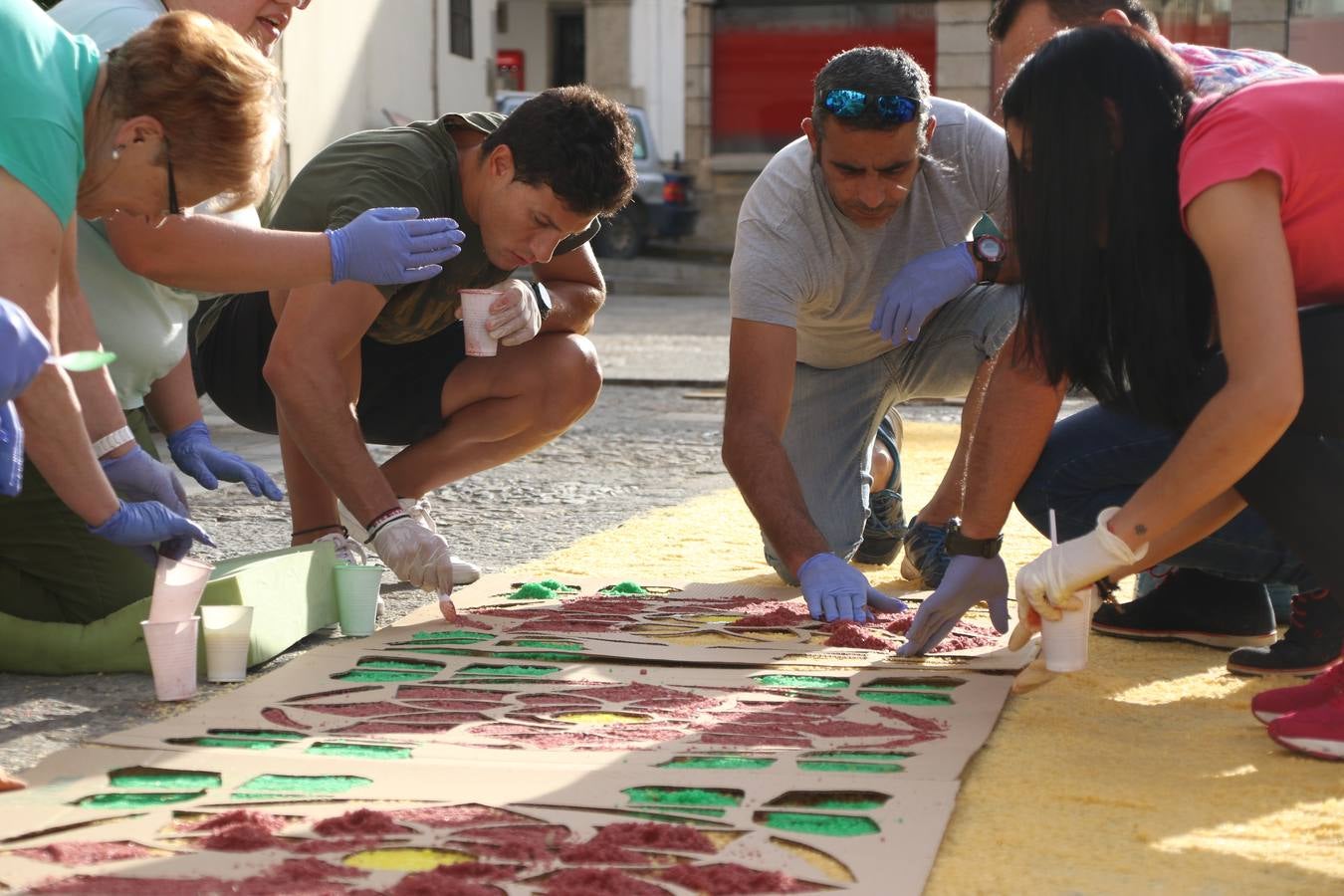 Las alfombras de sal embellecen y llenan de color, hoy, las calles de Jerez de los Caballeros con motivo de la festividad del Corpus Christi. Desde primera hora de la mañana, miembros de las cofradías y hermandades, Cáritas, grupos de catequesis, familias de los niños que han hecho este año la Primera Comunión, miembros de la Asociación de costaleros y costaleras de la Semana Santa jerezana, Ayuntamiento y vecinos han cubierto las principales calles del municipio con 6.250 kilos de sal teñida, plenas de color. A continuación, han disfrutado de una jornada de convivencia en la Casa de la Iglesia 'Cecilia de Arteaga'.