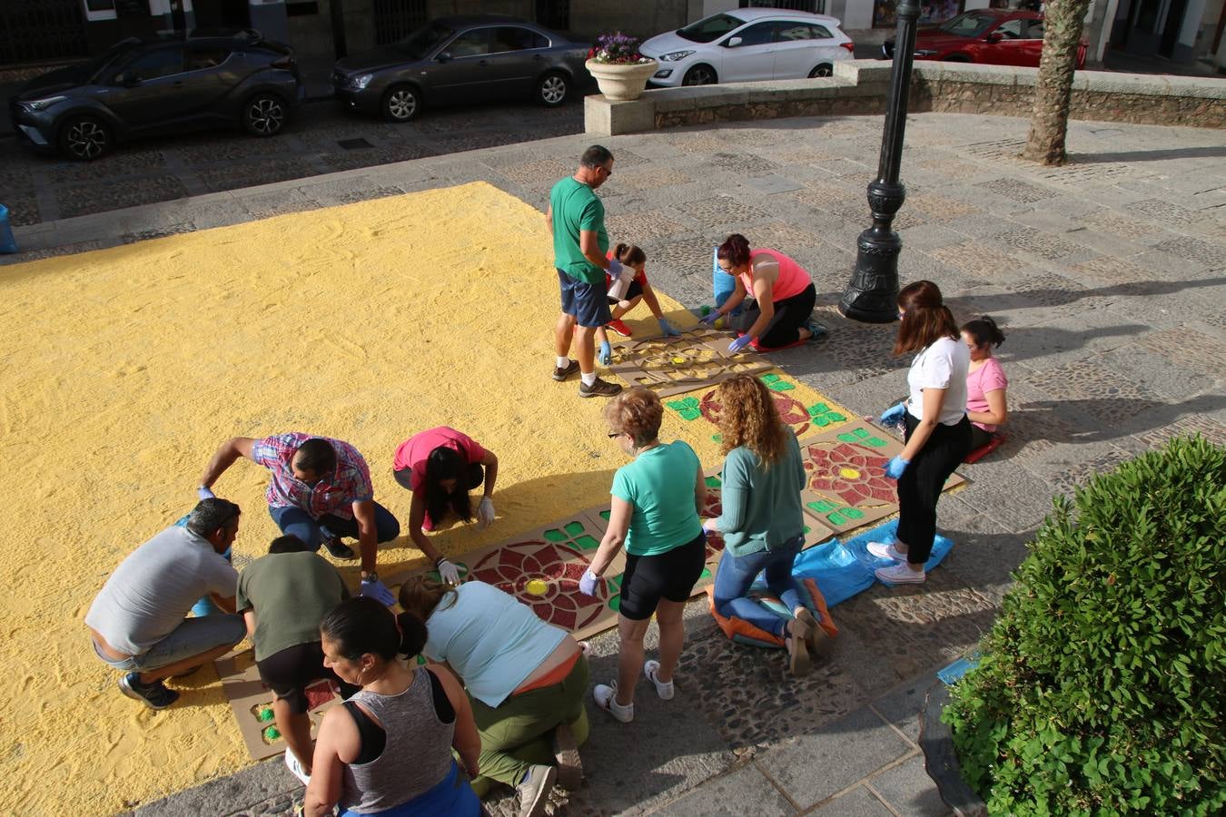 Las alfombras de sal embellecen y llenan de color, hoy, las calles de Jerez de los Caballeros con motivo de la festividad del Corpus Christi. Desde primera hora de la mañana, miembros de las cofradías y hermandades, Cáritas, grupos de catequesis, familias de los niños que han hecho este año la Primera Comunión, miembros de la Asociación de costaleros y costaleras de la Semana Santa jerezana, Ayuntamiento y vecinos han cubierto las principales calles del municipio con 6.250 kilos de sal teñida, plenas de color. A continuación, han disfrutado de una jornada de convivencia en la Casa de la Iglesia 'Cecilia de Arteaga'.