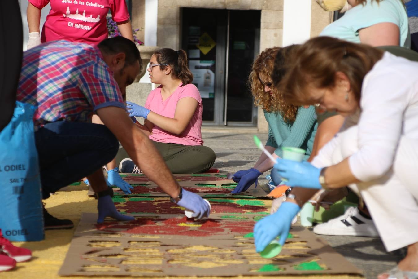 Las alfombras de sal embellecen y llenan de color, hoy, las calles de Jerez de los Caballeros con motivo de la festividad del Corpus Christi. Desde primera hora de la mañana, miembros de las cofradías y hermandades, Cáritas, grupos de catequesis, familias de los niños que han hecho este año la Primera Comunión, miembros de la Asociación de costaleros y costaleras de la Semana Santa jerezana, Ayuntamiento y vecinos han cubierto las principales calles del municipio con 6.250 kilos de sal teñida, plenas de color. A continuación, han disfrutado de una jornada de convivencia en la Casa de la Iglesia 'Cecilia de Arteaga'.