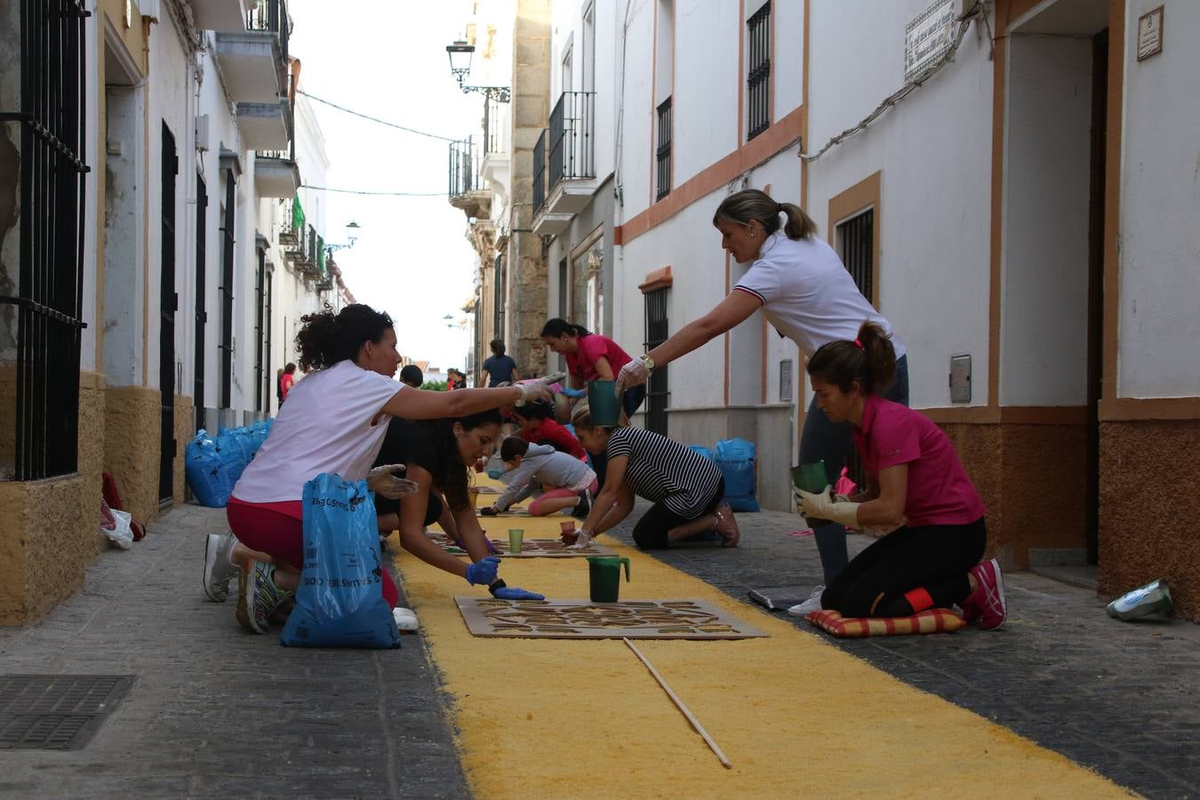 Las alfombras de sal embellecen y llenan de color, hoy, las calles de Jerez de los Caballeros con motivo de la festividad del Corpus Christi. Desde primera hora de la mañana, miembros de las cofradías y hermandades, Cáritas, grupos de catequesis, familias de los niños que han hecho este año la Primera Comunión, miembros de la Asociación de costaleros y costaleras de la Semana Santa jerezana, Ayuntamiento y vecinos han cubierto las principales calles del municipio con 6.250 kilos de sal teñida, plenas de color. A continuación, han disfrutado de una jornada de convivencia en la Casa de la Iglesia 'Cecilia de Arteaga'.