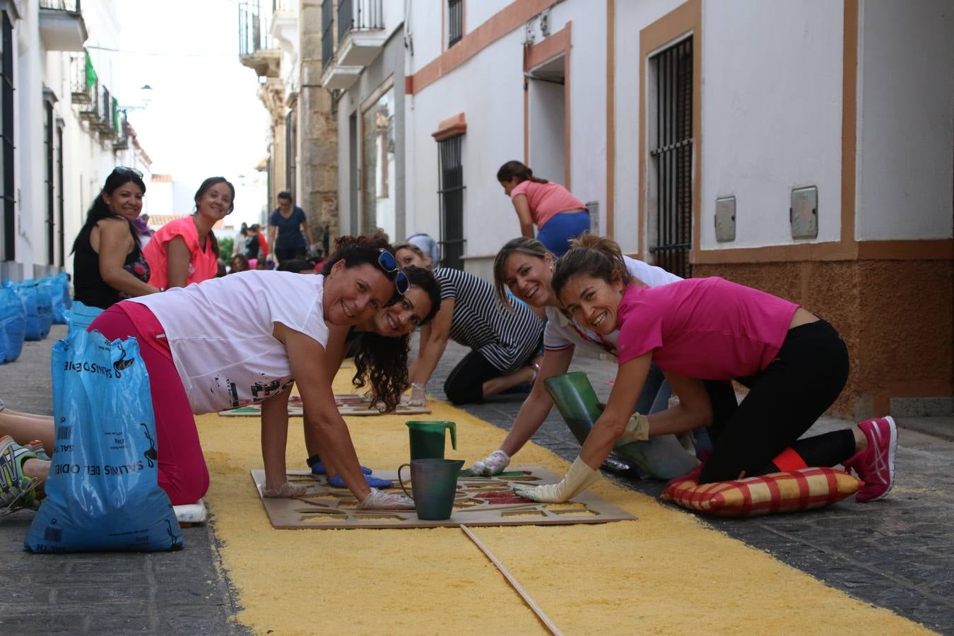 Las alfombras de sal embellecen y llenan de color, hoy, las calles de Jerez de los Caballeros con motivo de la festividad del Corpus Christi. Desde primera hora de la mañana, miembros de las cofradías y hermandades, Cáritas, grupos de catequesis, familias de los niños que han hecho este año la Primera Comunión, miembros de la Asociación de costaleros y costaleras de la Semana Santa jerezana, Ayuntamiento y vecinos han cubierto las principales calles del municipio con 6.250 kilos de sal teñida, plenas de color. A continuación, han disfrutado de una jornada de convivencia en la Casa de la Iglesia 'Cecilia de Arteaga'.