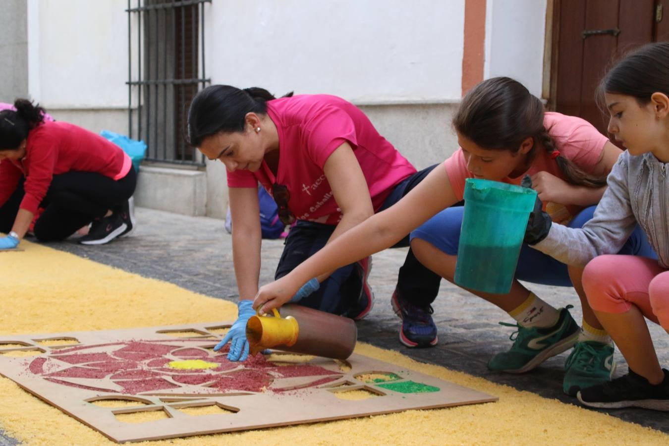 Las alfombras de sal embellecen y llenan de color, hoy, las calles de Jerez de los Caballeros con motivo de la festividad del Corpus Christi. Desde primera hora de la mañana, miembros de las cofradías y hermandades, Cáritas, grupos de catequesis, familias de los niños que han hecho este año la Primera Comunión, miembros de la Asociación de costaleros y costaleras de la Semana Santa jerezana, Ayuntamiento y vecinos han cubierto las principales calles del municipio con 6.250 kilos de sal teñida, plenas de color. A continuación, han disfrutado de una jornada de convivencia en la Casa de la Iglesia 'Cecilia de Arteaga'.