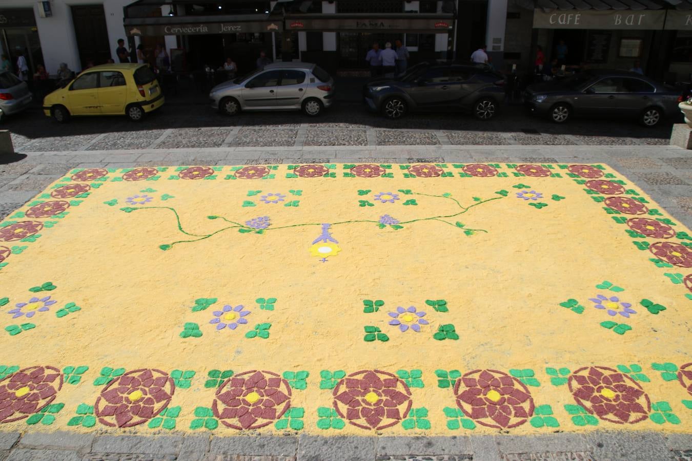 Las alfombras de sal embellecen y llenan de color, hoy, las calles de Jerez de los Caballeros con motivo de la festividad del Corpus Christi. Desde primera hora de la mañana, miembros de las cofradías y hermandades, Cáritas, grupos de catequesis, familias de los niños que han hecho este año la Primera Comunión, miembros de la Asociación de costaleros y costaleras de la Semana Santa jerezana, Ayuntamiento y vecinos han cubierto las principales calles del municipio con 6.250 kilos de sal teñida, plenas de color. A continuación, han disfrutado de una jornada de convivencia en la Casa de la Iglesia 'Cecilia de Arteaga'.