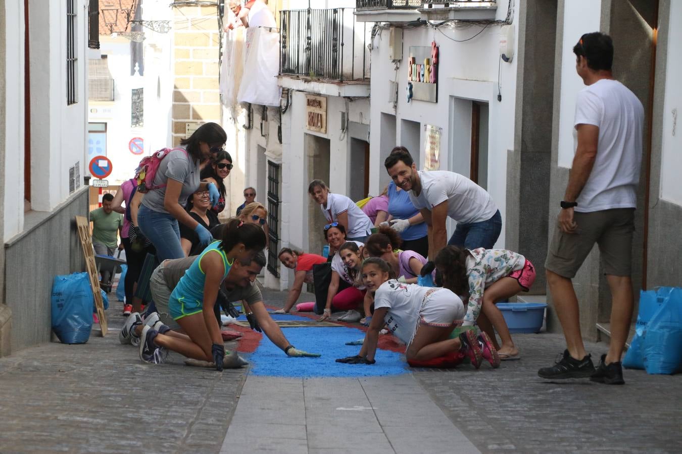 Las alfombras de sal embellecen y llenan de color, hoy, las calles de Jerez de los Caballeros con motivo de la festividad del Corpus Christi. Desde primera hora de la mañana, miembros de las cofradías y hermandades, Cáritas, grupos de catequesis, familias de los niños que han hecho este año la Primera Comunión, miembros de la Asociación de costaleros y costaleras de la Semana Santa jerezana, Ayuntamiento y vecinos han cubierto las principales calles del municipio con 6.250 kilos de sal teñida, plenas de color. A continuación, han disfrutado de una jornada de convivencia en la Casa de la Iglesia 'Cecilia de Arteaga'.