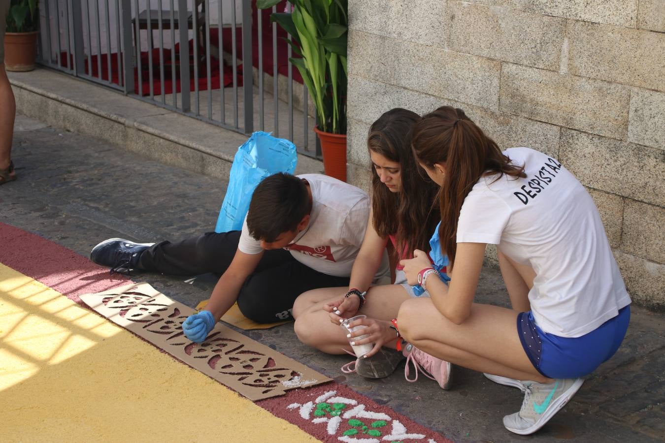 Las alfombras de sal embellecen y llenan de color, hoy, las calles de Jerez de los Caballeros con motivo de la festividad del Corpus Christi. Desde primera hora de la mañana, miembros de las cofradías y hermandades, Cáritas, grupos de catequesis, familias de los niños que han hecho este año la Primera Comunión, miembros de la Asociación de costaleros y costaleras de la Semana Santa jerezana, Ayuntamiento y vecinos han cubierto las principales calles del municipio con 6.250 kilos de sal teñida, plenas de color. A continuación, han disfrutado de una jornada de convivencia en la Casa de la Iglesia 'Cecilia de Arteaga'.