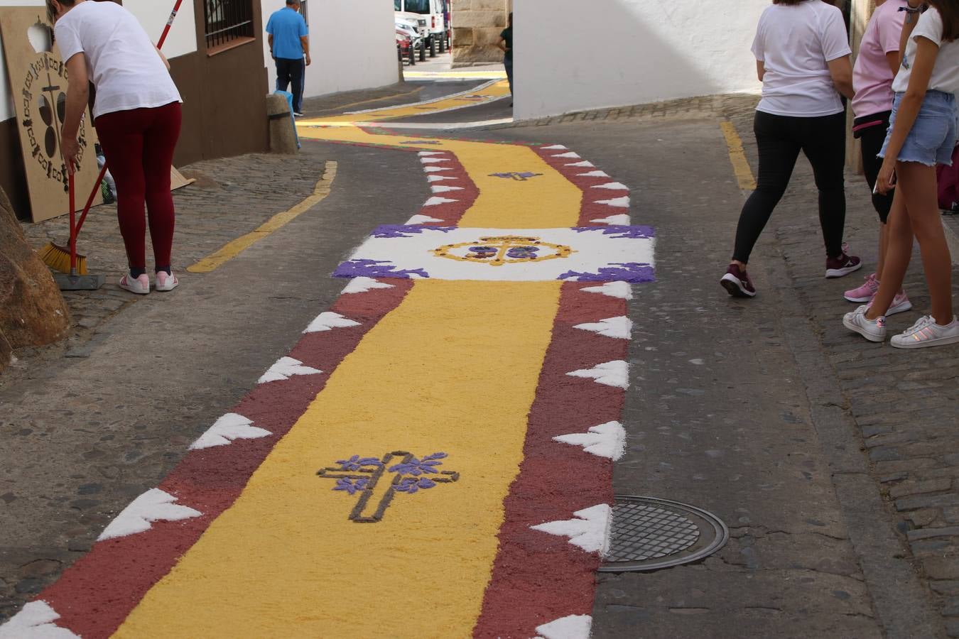 Las alfombras de sal embellecen y llenan de color, hoy, las calles de Jerez de los Caballeros con motivo de la festividad del Corpus Christi. Desde primera hora de la mañana, miembros de las cofradías y hermandades, Cáritas, grupos de catequesis, familias de los niños que han hecho este año la Primera Comunión, miembros de la Asociación de costaleros y costaleras de la Semana Santa jerezana, Ayuntamiento y vecinos han cubierto las principales calles del municipio con 6.250 kilos de sal teñida, plenas de color. A continuación, han disfrutado de una jornada de convivencia en la Casa de la Iglesia 'Cecilia de Arteaga'.