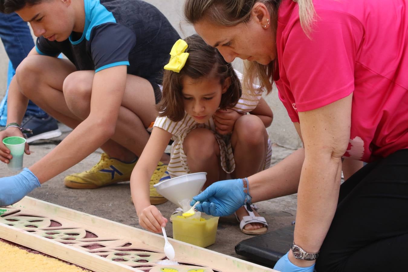 Las alfombras de sal embellecen y llenan de color, hoy, las calles de Jerez de los Caballeros con motivo de la festividad del Corpus Christi. Desde primera hora de la mañana, miembros de las cofradías y hermandades, Cáritas, grupos de catequesis, familias de los niños que han hecho este año la Primera Comunión, miembros de la Asociación de costaleros y costaleras de la Semana Santa jerezana, Ayuntamiento y vecinos han cubierto las principales calles del municipio con 6.250 kilos de sal teñida, plenas de color. A continuación, han disfrutado de una jornada de convivencia en la Casa de la Iglesia 'Cecilia de Arteaga'.