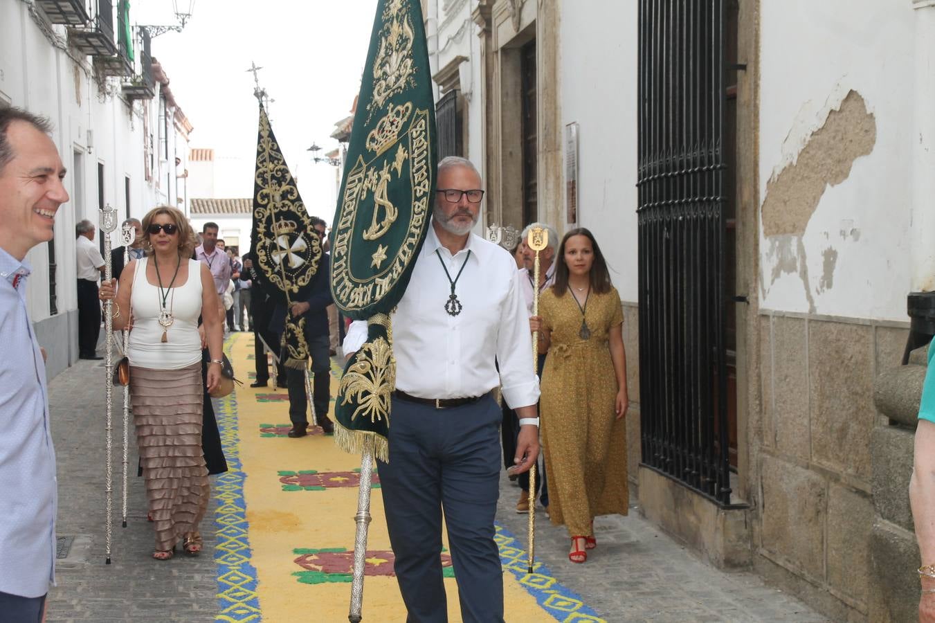 Jerez de los Caballeros celebró ayer la festividad del Corpus Christi en medio de un ambiente de solemnidad y convivencia del que fueron partícipes cientos de personas.La iglesia visigoda de Santa María de la Encarnación, llena de fieles, acogió la celebración de la Eucaristía que dió paso a la procesión acompañando la Santa Custodia en el magnífico templete de la iglesia de San Miguel, sobre las andas de la Virgen de Aguasantas y portada por costaleros y costaleras de la recién Asociación creada en esta ciudad. El párroco, Antonio María Rejano, destacó la significación de esta procesión, lamás grande, dijo, «porque Jesús sale a nuestras vidas, a nuestro encuentro y nosotros le acompañamos». Al término de la misa, incidió en el agradecimiento a todas las personas que han participado para hacer posible su desarrollo, trabajando desde la jornada del sábado en la elaboración de las preciosas alfombras de sal teñida de colores, que lucieron en las calles del centro de Jerez. El agradecimiento fue especial para los padres y madres de los niños y niñas que han hecho la Primera Comunión, para éstos mismos, también para catequistas, Cofradías y Hermandades, la Asociación del costaleros y costaleras de la Semana Santa de Jerez de los Caballeros, Ayuntamiento, Policía Local, grupos y personas de la parroquia.Autoridades civiles en representación del Ayuntamiento, Policía Local y Guardia Civil, acompañaron el desarrollo de la procesión junto a representantes de todas las cofradías y hermandades jerezanas y el protagonismo de los más de 80 niños y niñas que este año han celebrado su Primera Comunión.  A lo largo de todo el recorrido se instalaron distintos altares, también con la colaboración de vecinos y centros como la Residencia de Mayores Hernando de Soto. Los magníficos sones de la Agrupación Musical 'Nuestro Padre Jesús Nazareno' coronaron esta hermosa procesión.