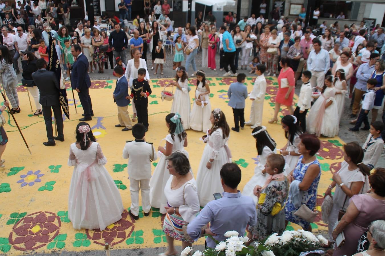Jerez de los Caballeros celebró ayer la festividad del Corpus Christi en medio de un ambiente de solemnidad y convivencia del que fueron partícipes cientos de personas.La iglesia visigoda de Santa María de la Encarnación, llena de fieles, acogió la celebración de la Eucaristía que dió paso a la procesión acompañando la Santa Custodia en el magnífico templete de la iglesia de San Miguel, sobre las andas de la Virgen de Aguasantas y portada por costaleros y costaleras de la recién Asociación creada en esta ciudad. El párroco, Antonio María Rejano, destacó la significación de esta procesión, lamás grande, dijo, «porque Jesús sale a nuestras vidas, a nuestro encuentro y nosotros le acompañamos». Al término de la misa, incidió en el agradecimiento a todas las personas que han participado para hacer posible su desarrollo, trabajando desde la jornada del sábado en la elaboración de las preciosas alfombras de sal teñida de colores, que lucieron en las calles del centro de Jerez. El agradecimiento fue especial para los padres y madres de los niños y niñas que han hecho la Primera Comunión, para éstos mismos, también para catequistas, Cofradías y Hermandades, la Asociación del costaleros y costaleras de la Semana Santa de Jerez de los Caballeros, Ayuntamiento, Policía Local, grupos y personas de la parroquia.Autoridades civiles en representación del Ayuntamiento, Policía Local y Guardia Civil, acompañaron el desarrollo de la procesión junto a representantes de todas las cofradías y hermandades jerezanas y el protagonismo de los más de 80 niños y niñas que este año han celebrado su Primera Comunión.  A lo largo de todo el recorrido se instalaron distintos altares, también con la colaboración de vecinos y centros como la Residencia de Mayores Hernando de Soto. Los magníficos sones de la Agrupación Musical 'Nuestro Padre Jesús Nazareno' coronaron esta hermosa procesión.