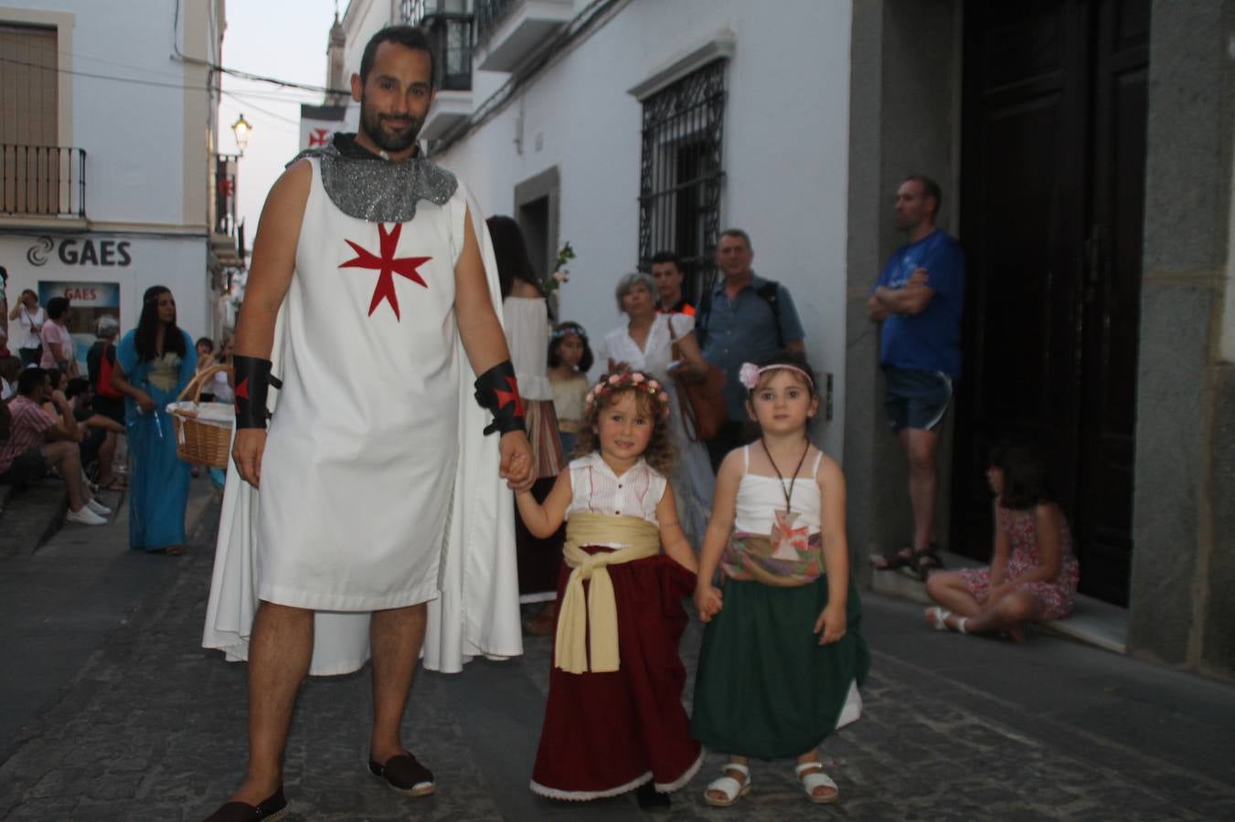 La participación popular fue nuevo protagonista del desfile teatralizado que anoche inauguró el grueso de la programación del XVI Festival Templario, invitando a propios y visitantes a revivir un pasado de leyenda, concretamente el siglo en el que La Orden del Temple marcó la vida de esta ciudad, en la que tuvo una de sus principales Encomiendas, siendo además el último reducto de Los Templarios en los reinos de España.La Asociación juvenil y cultural 'La Trouppe' estuvo al frente de la coordinación de dicho desfile que llenó de ambiente y animación las calles y plazas del centro histórico de Jerez de los Caballeros, llenas de público y engalanadas para la ocasión con pendones con la cruz templaria y otros elementos referentes a la cultura árabe que dejó su impronta en aquella época. Destacó la participación de más de 60 niñas que pusieron alegría con sus bailes a este pasacalle, junto a personajes fantásticos en zancos, la melodía de la Asociación Musical de Jerez de los Caballeros y la participación de asociaciones, como la del Belén 'Santa Ángela', Euexia Rural, además de los caballeros del campamento medieval a cargo de Cabalbur y de manera especial, la implicación de numerosos vecinos de todas las edades que desfilaron ataviados con indumentaria de la época dando vida a esta celebración.