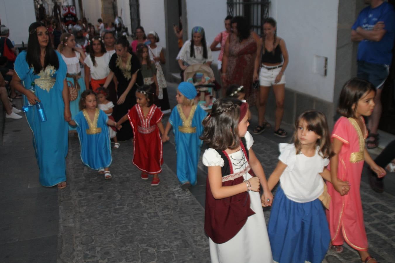 La participación popular fue nuevo protagonista del desfile teatralizado que anoche inauguró el grueso de la programación del XVI Festival Templario, invitando a propios y visitantes a revivir un pasado de leyenda, concretamente el siglo en el que La Orden del Temple marcó la vida de esta ciudad, en la que tuvo una de sus principales Encomiendas, siendo además el último reducto de Los Templarios en los reinos de España.La Asociación juvenil y cultural 'La Trouppe' estuvo al frente de la coordinación de dicho desfile que llenó de ambiente y animación las calles y plazas del centro histórico de Jerez de los Caballeros, llenas de público y engalanadas para la ocasión con pendones con la cruz templaria y otros elementos referentes a la cultura árabe que dejó su impronta en aquella época. Destacó la participación de más de 60 niñas que pusieron alegría con sus bailes a este pasacalle, junto a personajes fantásticos en zancos, la melodía de la Asociación Musical de Jerez de los Caballeros y la participación de asociaciones, como la del Belén 'Santa Ángela', Euexia Rural, además de los caballeros del campamento medieval a cargo de Cabalbur y de manera especial, la implicación de numerosos vecinos de todas las edades que desfilaron ataviados con indumentaria de la época dando vida a esta celebración.
