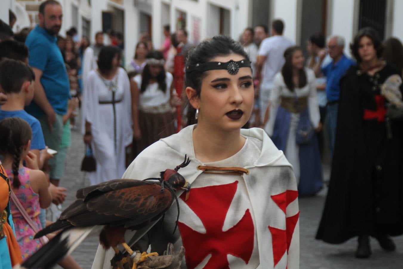 La participación popular fue nuevo protagonista del desfile teatralizado que anoche inauguró el grueso de la programación del XVI Festival Templario, invitando a propios y visitantes a revivir un pasado de leyenda, concretamente el siglo en el que La Orden del Temple marcó la vida de esta ciudad, en la que tuvo una de sus principales Encomiendas, siendo además el último reducto de Los Templarios en los reinos de España.La Asociación juvenil y cultural 'La Trouppe' estuvo al frente de la coordinación de dicho desfile que llenó de ambiente y animación las calles y plazas del centro histórico de Jerez de los Caballeros, llenas de público y engalanadas para la ocasión con pendones con la cruz templaria y otros elementos referentes a la cultura árabe que dejó su impronta en aquella época. Destacó la participación de más de 60 niñas que pusieron alegría con sus bailes a este pasacalle, junto a personajes fantásticos en zancos, la melodía de la Asociación Musical de Jerez de los Caballeros y la participación de asociaciones, como la del Belén 'Santa Ángela', Euexia Rural, además de los caballeros del campamento medieval a cargo de Cabalbur y de manera especial, la implicación de numerosos vecinos de todas las edades que desfilaron ataviados con indumentaria de la época dando vida a esta celebración.