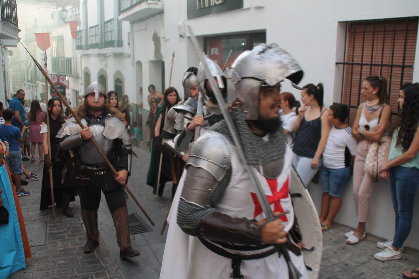 La participación popular fue nuevo protagonista del desfile teatralizado que anoche inauguró el grueso de la programación del XVI Festival Templario, invitando a propios y visitantes a revivir un pasado de leyenda, concretamente el siglo en el que La Orden del Temple marcó la vida de esta ciudad, en la que tuvo una de sus principales Encomiendas, siendo además el último reducto de Los Templarios en los reinos de España.La Asociación juvenil y cultural 'La Trouppe' estuvo al frente de la coordinación de dicho desfile que llenó de ambiente y animación las calles y plazas del centro histórico de Jerez de los Caballeros, llenas de público y engalanadas para la ocasión con pendones con la cruz templaria y otros elementos referentes a la cultura árabe que dejó su impronta en aquella época. Destacó la participación de más de 60 niñas que pusieron alegría con sus bailes a este pasacalle, junto a personajes fantásticos en zancos, la melodía de la Asociación Musical de Jerez de los Caballeros y la participación de asociaciones, como la del Belén 'Santa Ángela', Euexia Rural, además de los caballeros del campamento medieval a cargo de Cabalbur y de manera especial, la implicación de numerosos vecinos de todas las edades que desfilaron ataviados con indumentaria de la época dando vida a esta celebración.