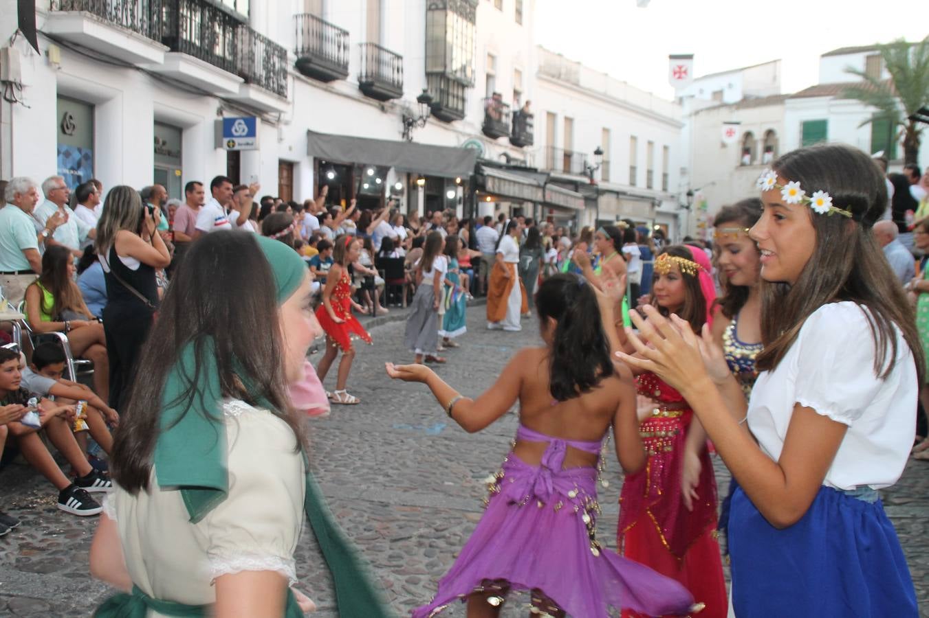 La participación popular fue nuevo protagonista del desfile teatralizado que anoche inauguró el grueso de la programación del XVI Festival Templario, invitando a propios y visitantes a revivir un pasado de leyenda, concretamente el siglo en el que La Orden del Temple marcó la vida de esta ciudad, en la que tuvo una de sus principales Encomiendas, siendo además el último reducto de Los Templarios en los reinos de España.La Asociación juvenil y cultural 'La Trouppe' estuvo al frente de la coordinación de dicho desfile que llenó de ambiente y animación las calles y plazas del centro histórico de Jerez de los Caballeros, llenas de público y engalanadas para la ocasión con pendones con la cruz templaria y otros elementos referentes a la cultura árabe que dejó su impronta en aquella época. Destacó la participación de más de 60 niñas que pusieron alegría con sus bailes a este pasacalle, junto a personajes fantásticos en zancos, la melodía de la Asociación Musical de Jerez de los Caballeros y la participación de asociaciones, como la del Belén 'Santa Ángela', Euexia Rural, además de los caballeros del campamento medieval a cargo de Cabalbur y de manera especial, la implicación de numerosos vecinos de todas las edades que desfilaron ataviados con indumentaria de la época dando vida a esta celebración.