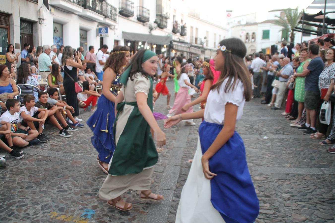 La participación popular fue nuevo protagonista del desfile teatralizado que anoche inauguró el grueso de la programación del XVI Festival Templario, invitando a propios y visitantes a revivir un pasado de leyenda, concretamente el siglo en el que La Orden del Temple marcó la vida de esta ciudad, en la que tuvo una de sus principales Encomiendas, siendo además el último reducto de Los Templarios en los reinos de España.La Asociación juvenil y cultural 'La Trouppe' estuvo al frente de la coordinación de dicho desfile que llenó de ambiente y animación las calles y plazas del centro histórico de Jerez de los Caballeros, llenas de público y engalanadas para la ocasión con pendones con la cruz templaria y otros elementos referentes a la cultura árabe que dejó su impronta en aquella época. Destacó la participación de más de 60 niñas que pusieron alegría con sus bailes a este pasacalle, junto a personajes fantásticos en zancos, la melodía de la Asociación Musical de Jerez de los Caballeros y la participación de asociaciones, como la del Belén 'Santa Ángela', Euexia Rural, además de los caballeros del campamento medieval a cargo de Cabalbur y de manera especial, la implicación de numerosos vecinos de todas las edades que desfilaron ataviados con indumentaria de la época dando vida a esta celebración.