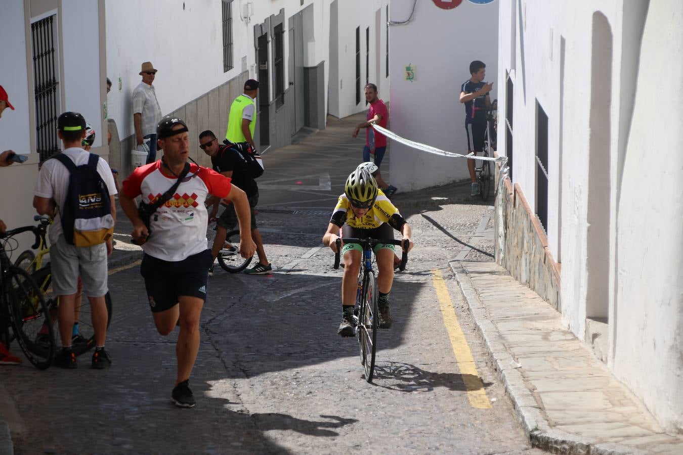 El barrio de 'Santa Catalina' de Jerez de los Caballeros ha acogido, esta mañana, la tercera prueba del Gran Premio Diputación de Badajoz 'Copa Escuelas de ciclismo en carretera', organizada por el Club Ciclista Jerez de los Caballeros y la Federación Extremeña de Ciclismo.Una competición de ciclismo que, como ya adelantó HOY Jerez, fue creada por la Federación Extremeña de Ciclismo con el objetivo de fomentar y seguir practicando deporte cuando ya han terminado todos los circuitos que se celebran durante el curso académico. En la citada prueba, han participado diferentes categorías: cadete, promesa, junior, principiante, alevín e infantil.Juan Luis Soriano, presidente del Club Ciclista Jerez, ha manifestado su satisfacción por el buen desarrollo de la jornada, «este tipo de pruebas son fundamentales para hacer cantera y promover este deporte entre los más pequeños».