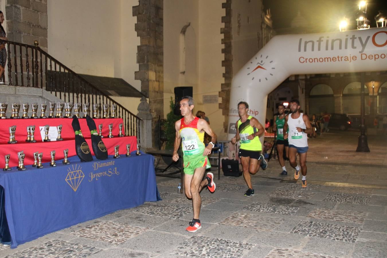La Plaza de España de Jerez de los Caballeros acogió, ayer, la V Carrera Popular Nocturna 'Recorriendo el Medievo', organizada por el Ayuntamiento del municipio con la colaboración del Plan de Dinamización Deportiva de la Mancomunidad Sierra Suroeste. Las principales calles del municipio volvieron a convertirse en el mejor escenario para el desarrollo de esta prueba deportiva que, año tras año, se consolida como una de las citas más destacadas del calendario estival jerezano y en la que la solidaridad, también, está muy presente. Así, se lograron recaudar 153 kilos y 22 euros que irán destinados al almacén de alimentos que gestiona la Asamblea local de Cruz Roja en el municipio.En esta edición, han participado unos 200 corredores de la localidad y alrededores, siendo Manuel Gómez Lucas y Tina María Ramos, vencedores de la clasificación general.