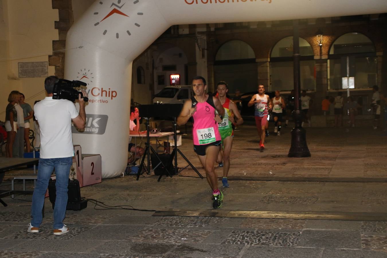 La Plaza de España de Jerez de los Caballeros acogió, ayer, la V Carrera Popular Nocturna 'Recorriendo el Medievo', organizada por el Ayuntamiento del municipio con la colaboración del Plan de Dinamización Deportiva de la Mancomunidad Sierra Suroeste. Las principales calles del municipio volvieron a convertirse en el mejor escenario para el desarrollo de esta prueba deportiva que, año tras año, se consolida como una de las citas más destacadas del calendario estival jerezano y en la que la solidaridad, también, está muy presente. Así, se lograron recaudar 153 kilos y 22 euros que irán destinados al almacén de alimentos que gestiona la Asamblea local de Cruz Roja en el municipio.En esta edición, han participado unos 200 corredores de la localidad y alrededores, siendo Manuel Gómez Lucas y Tina María Ramos, vencedores de la clasificación general.