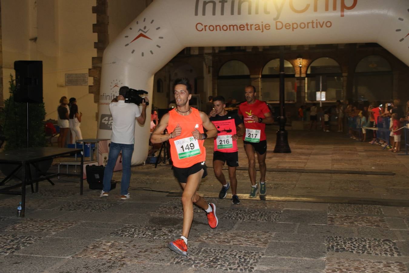 La Plaza de España de Jerez de los Caballeros acogió, ayer, la V Carrera Popular Nocturna 'Recorriendo el Medievo', organizada por el Ayuntamiento del municipio con la colaboración del Plan de Dinamización Deportiva de la Mancomunidad Sierra Suroeste. Las principales calles del municipio volvieron a convertirse en el mejor escenario para el desarrollo de esta prueba deportiva que, año tras año, se consolida como una de las citas más destacadas del calendario estival jerezano y en la que la solidaridad, también, está muy presente. Así, se lograron recaudar 153 kilos y 22 euros que irán destinados al almacén de alimentos que gestiona la Asamblea local de Cruz Roja en el municipio.En esta edición, han participado unos 200 corredores de la localidad y alrededores, siendo Manuel Gómez Lucas y Tina María Ramos, vencedores de la clasificación general.
