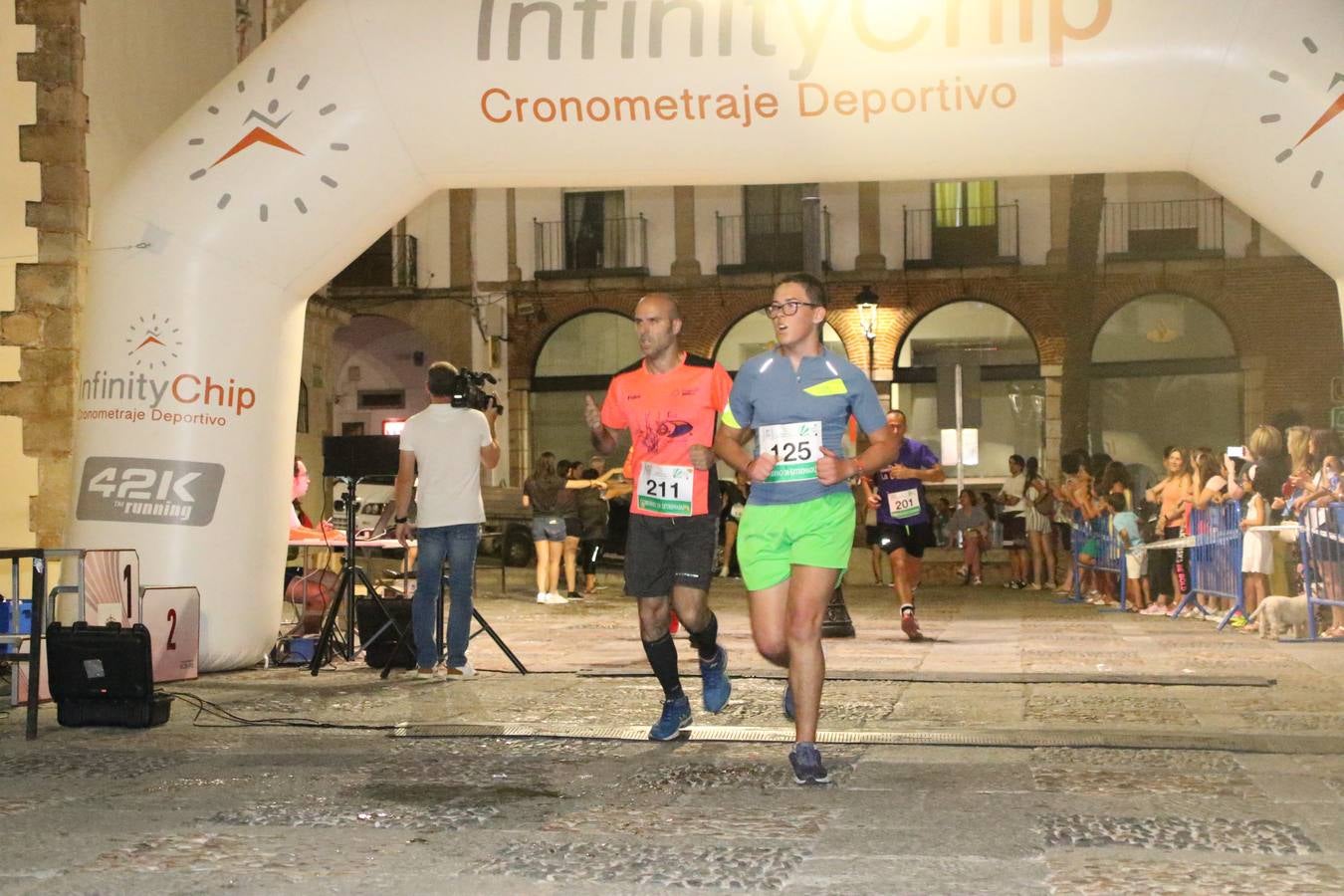La Plaza de España de Jerez de los Caballeros acogió, ayer, la V Carrera Popular Nocturna 'Recorriendo el Medievo', organizada por el Ayuntamiento del municipio con la colaboración del Plan de Dinamización Deportiva de la Mancomunidad Sierra Suroeste. Las principales calles del municipio volvieron a convertirse en el mejor escenario para el desarrollo de esta prueba deportiva que, año tras año, se consolida como una de las citas más destacadas del calendario estival jerezano y en la que la solidaridad, también, está muy presente. Así, se lograron recaudar 153 kilos y 22 euros que irán destinados al almacén de alimentos que gestiona la Asamblea local de Cruz Roja en el municipio.En esta edición, han participado unos 200 corredores de la localidad y alrededores, siendo Manuel Gómez Lucas y Tina María Ramos, vencedores de la clasificación general.