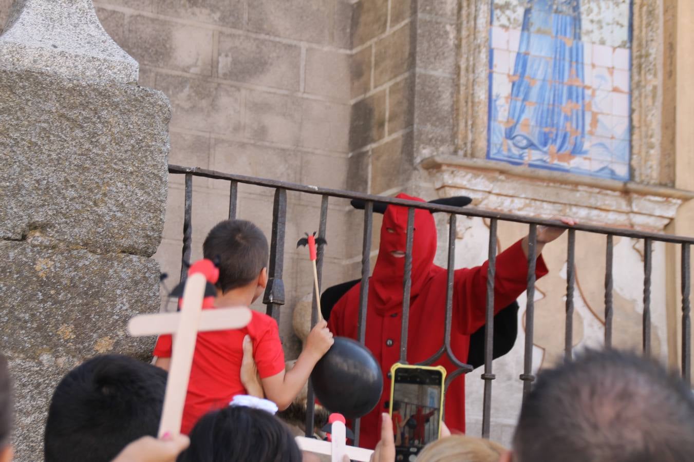 El repique de las campanas de San Bartolomé ha sonado este viernes, 23 de agosto, muy alegre, para anunciar la 'Salida del diablo', una de las tradiciones más ancestrales de Jerez de los Caballeros que anunciar la festividad de San Bartolomé, patrón de la ciudad. Organizada por la Comisión integrada en la Archicofradía del Santísimo Sacramento, la citada representación se ha vivido con gran expectación y emoción y este año con sorpresa. El recorrido del diablo por las calles ha hecho las decilicias de cientos de niños y niñas que han disfrutado de la cita, al tiempo que han contribuido a revivir esta gran celebración cargada de simbología, pues la figura del diablo aparece representada a los pies del patrón, encadenada, representando el triunfo del bien sobre el mal. Cada 23 de agosto, se libera de esas cadenas y recorre la localidad templaria, escoba en mano. La única forma de hacer frente a su ira, es mostrarle una cruz, por ello hoy la imagen más entrañable la han protagonizado los más pequeños portando en sus manos pequeñas cruces de madera para, como manda la tradición, «evitar que el diablo les coja». La cita da paso esta noche a la también tradicional 'Quema del rabo del diablo' que organizan los amigos de esta representación a las 22 horas en el Llano de Santa María y con el fuego como elemento purificador.