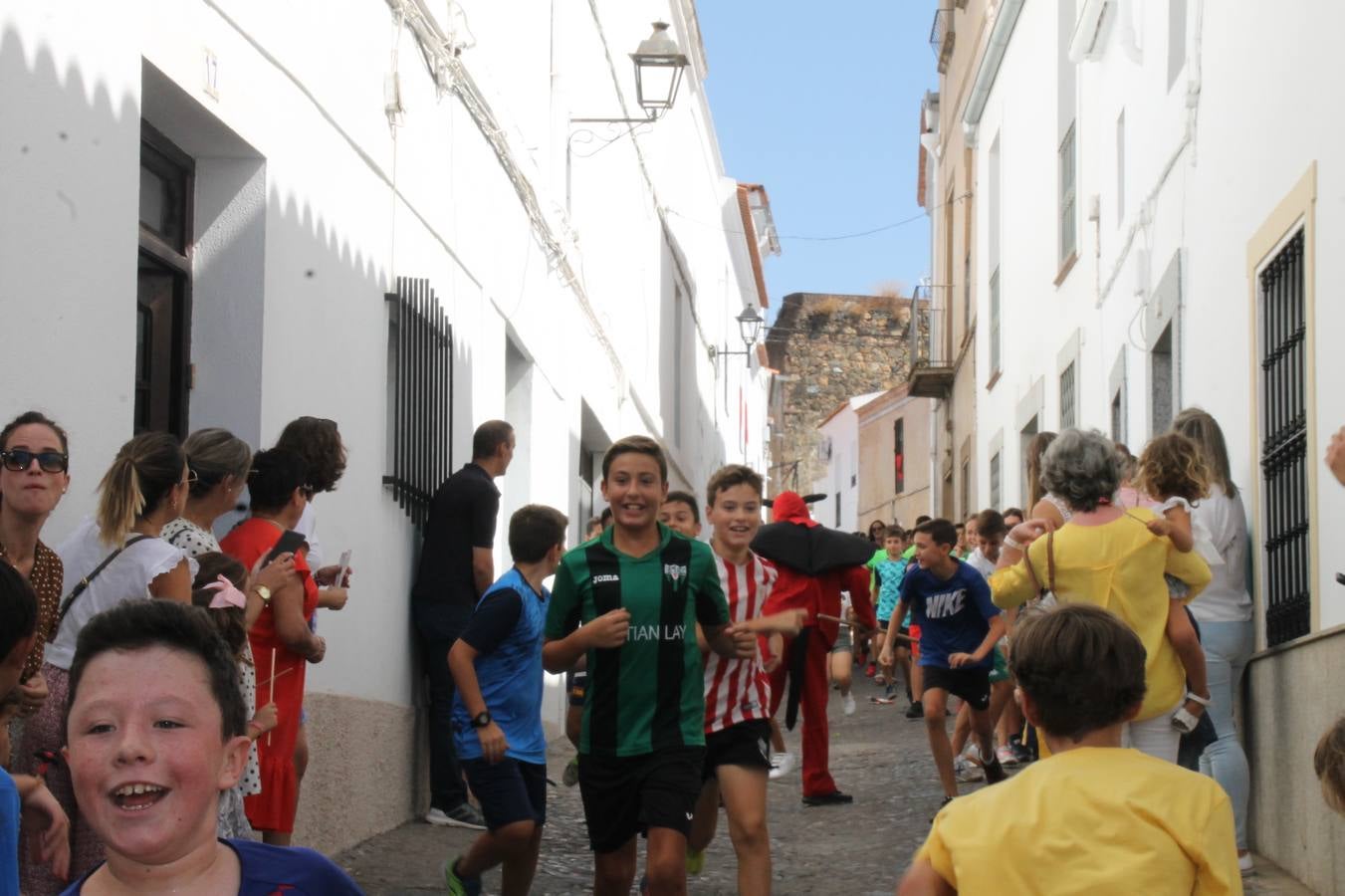 El repique de las campanas de San Bartolomé ha sonado este viernes, 23 de agosto, muy alegre, para anunciar la 'Salida del diablo', una de las tradiciones más ancestrales de Jerez de los Caballeros que anunciar la festividad de San Bartolomé, patrón de la ciudad. Organizada por la Comisión integrada en la Archicofradía del Santísimo Sacramento, la citada representación se ha vivido con gran expectación y emoción y este año con sorpresa. El recorrido del diablo por las calles ha hecho las decilicias de cientos de niños y niñas que han disfrutado de la cita, al tiempo que han contribuido a revivir esta gran celebración cargada de simbología, pues la figura del diablo aparece representada a los pies del patrón, encadenada, representando el triunfo del bien sobre el mal. Cada 23 de agosto, se libera de esas cadenas y recorre la localidad templaria, escoba en mano. La única forma de hacer frente a su ira, es mostrarle una cruz, por ello hoy la imagen más entrañable la han protagonizado los más pequeños portando en sus manos pequeñas cruces de madera para, como manda la tradición, «evitar que el diablo les coja». La cita da paso esta noche a la también tradicional 'Quema del rabo del diablo' que organizan los amigos de esta representación a las 22 horas en el Llano de Santa María y con el fuego como elemento purificador.