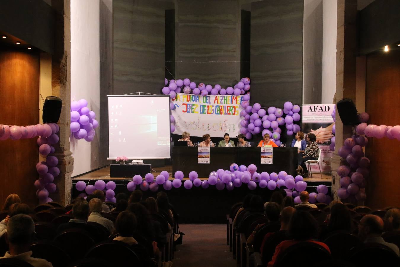 Ante las condiciones climatológicas adversas, el auditorio del Conventual San Agustín se convirtió en el mejor escenario para acoger las actividades que, con motivo del Día Mundial del Alzhéimer, la Asociación de Familiares de Personas con Alzheimer y otras Demencias de Jerez de los Caballeros y Comarca Sierra Suroeste (AFAD) había preparado en el municipio. Una gran pancarta con el lema 'Evolución', realizada por los alumnos del Colegio de Educación Especial 'Nuestra Señora de Aguasantas', presidió el escenario, y una marea de globos morados con distintos dibujos, realizados por los alumnos de los colegios 'Sotomayor y Terrazas' y 'El Rodeo', tiñó de color, empatía, sensibilidad y creatividad el citado auditorio.La jornada comenzó con la canción 'Estoy contigo' de la Oreja de Van Gogh. A continuación, tuvo lugar una mesa redonda en la que cinco personas contaron su testimonio en relación a esta enfermedad. Posteriormente, se dio paso a la lectura de un manifiesto; la entrega de diploma a las personas y colectivos colaboradores, y la lectura de dos cuentos infantiles.