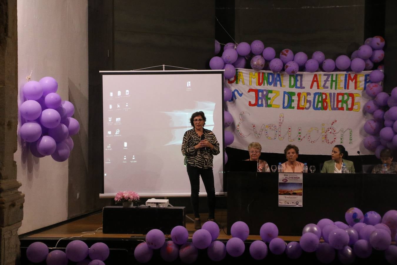 Ante las condiciones climatológicas adversas, el auditorio del Conventual San Agustín se convirtió en el mejor escenario para acoger las actividades que, con motivo del Día Mundial del Alzhéimer, la Asociación de Familiares de Personas con Alzheimer y otras Demencias de Jerez de los Caballeros y Comarca Sierra Suroeste (AFAD) había preparado en el municipio. Una gran pancarta con el lema 'Evolución', realizada por los alumnos del Colegio de Educación Especial 'Nuestra Señora de Aguasantas', presidió el escenario, y una marea de globos morados con distintos dibujos, realizados por los alumnos de los colegios 'Sotomayor y Terrazas' y 'El Rodeo', tiñó de color, empatía, sensibilidad y creatividad el citado auditorio.La jornada comenzó con la canción 'Estoy contigo' de la Oreja de Van Gogh. A continuación, tuvo lugar una mesa redonda en la que cinco personas contaron su testimonio en relación a esta enfermedad. Posteriormente, se dio paso a la lectura de un manifiesto; la entrega de diploma a las personas y colectivos colaboradores, y la lectura de dos cuentos infantiles.