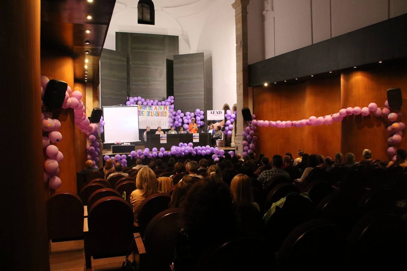 Ante las condiciones climatológicas adversas, el auditorio del Conventual San Agustín se convirtió en el mejor escenario para acoger las actividades que, con motivo del Día Mundial del Alzhéimer, la Asociación de Familiares de Personas con Alzheimer y otras Demencias de Jerez de los Caballeros y Comarca Sierra Suroeste (AFAD) había preparado en el municipio. Una gran pancarta con el lema 'Evolución', realizada por los alumnos del Colegio de Educación Especial 'Nuestra Señora de Aguasantas', presidió el escenario, y una marea de globos morados con distintos dibujos, realizados por los alumnos de los colegios 'Sotomayor y Terrazas' y 'El Rodeo', tiñó de color, empatía, sensibilidad y creatividad el citado auditorio.La jornada comenzó con la canción 'Estoy contigo' de la Oreja de Van Gogh. A continuación, tuvo lugar una mesa redonda en la que cinco personas contaron su testimonio en relación a esta enfermedad. Posteriormente, se dio paso a la lectura de un manifiesto; la entrega de diploma a las personas y colectivos colaboradores, y la lectura de dos cuentos infantiles.