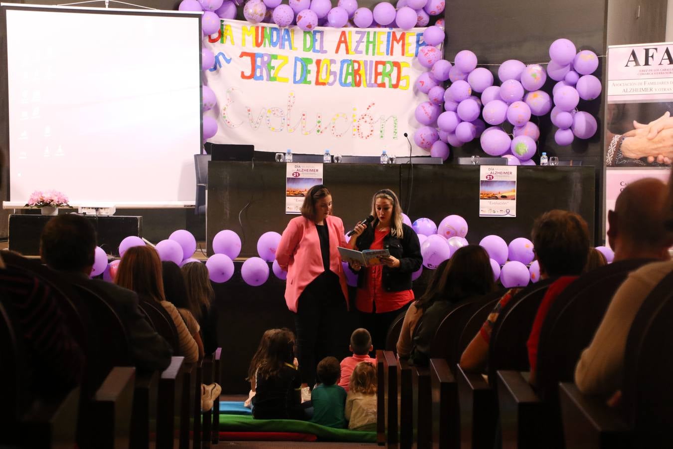 Ante las condiciones climatológicas adversas, el auditorio del Conventual San Agustín se convirtió en el mejor escenario para acoger las actividades que, con motivo del Día Mundial del Alzhéimer, la Asociación de Familiares de Personas con Alzheimer y otras Demencias de Jerez de los Caballeros y Comarca Sierra Suroeste (AFAD) había preparado en el municipio. Una gran pancarta con el lema 'Evolución', realizada por los alumnos del Colegio de Educación Especial 'Nuestra Señora de Aguasantas', presidió el escenario, y una marea de globos morados con distintos dibujos, realizados por los alumnos de los colegios 'Sotomayor y Terrazas' y 'El Rodeo', tiñó de color, empatía, sensibilidad y creatividad el citado auditorio.La jornada comenzó con la canción 'Estoy contigo' de la Oreja de Van Gogh. A continuación, tuvo lugar una mesa redonda en la que cinco personas contaron su testimonio en relación a esta enfermedad. Posteriormente, se dio paso a la lectura de un manifiesto; la entrega de diploma a las personas y colectivos colaboradores, y la lectura de dos cuentos infantiles.