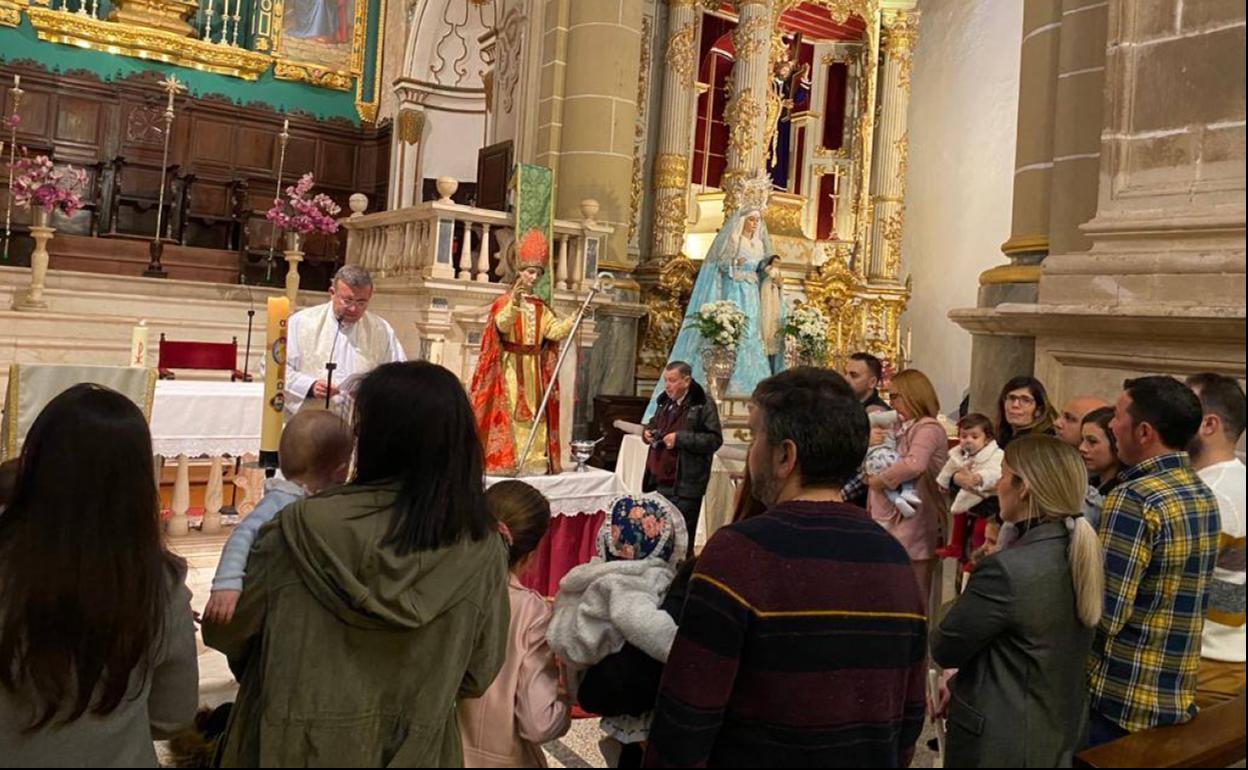 Madres y padres con sus hijos participando de la celebración de La Candelaria.