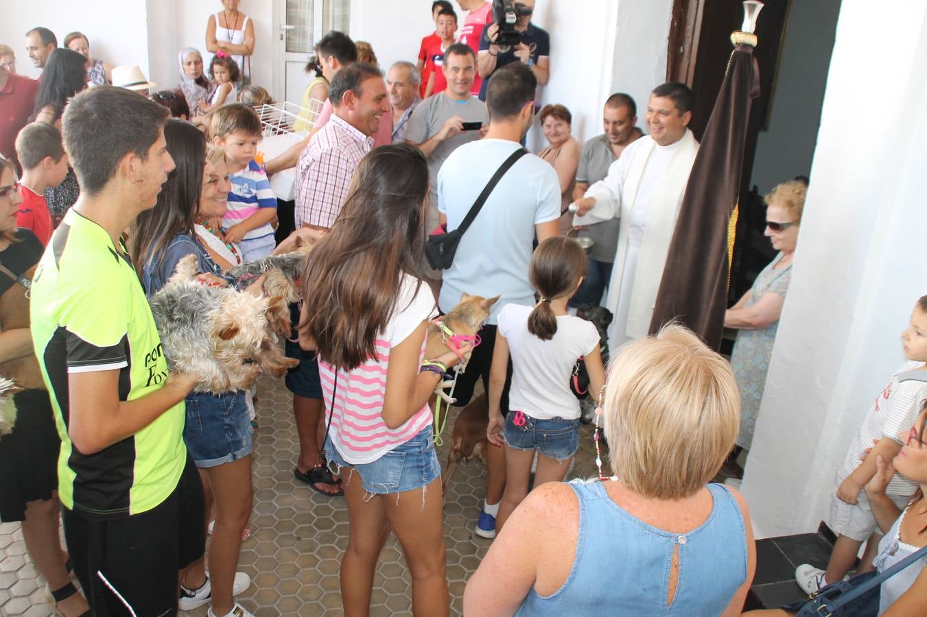 Personas de todas las edades acuden a la ermita de San Roque con sus mascotas para recibir la bendición del sacerdote en el día de la festividad del Santo.