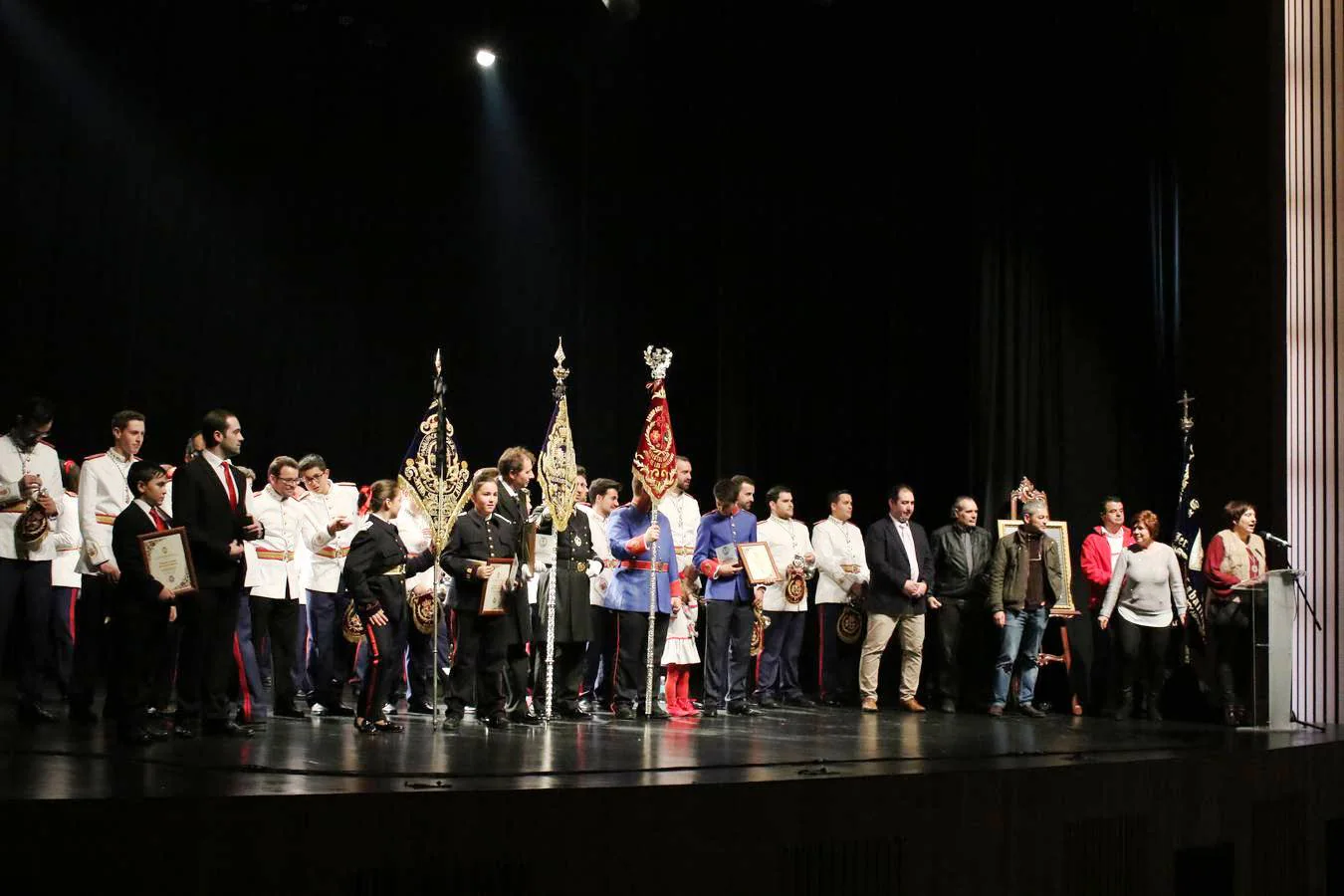 Miemnbros de las distintas bandas y agrupaciones junto a representantes de la Junta de Cofradías tras recoger un obsequio en agradecimiento a su participación en el Certamen.