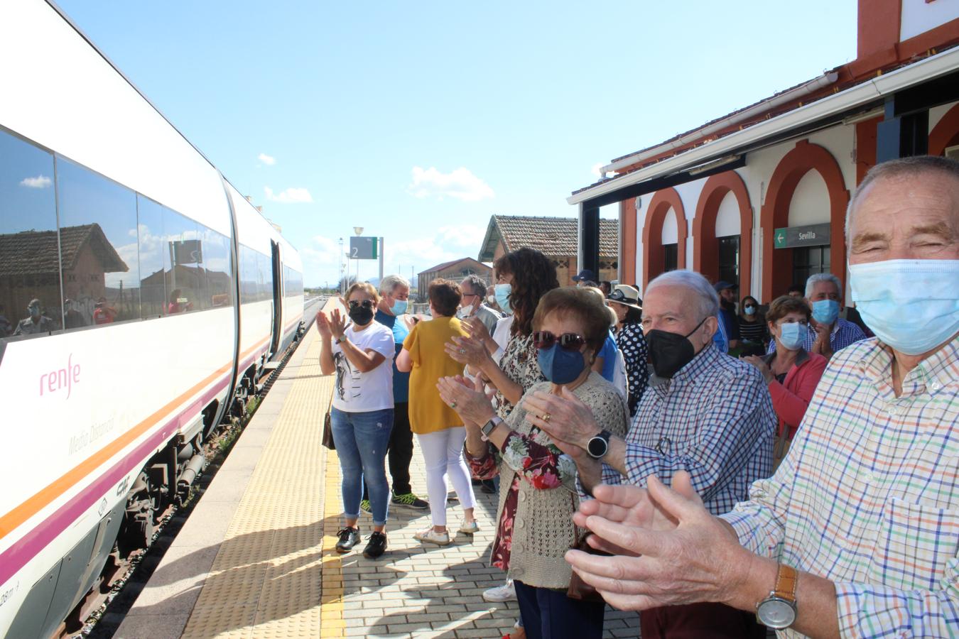 Manifestantes aplauden al tren que llega desde Sevilla en la estación de tren.