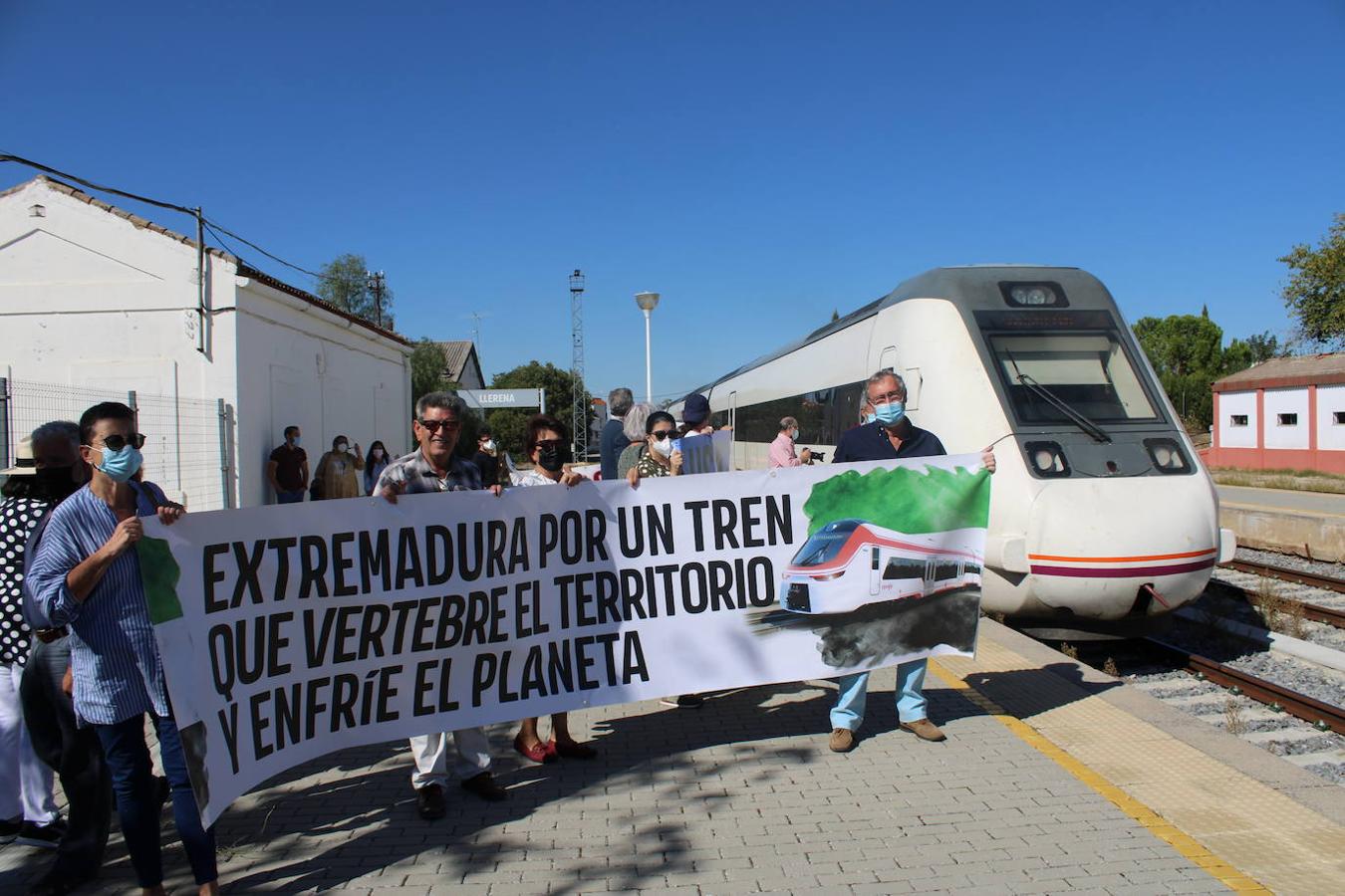 Manifestantes posan con una pancarta mientras el tren se marcha con destino a Madrid.