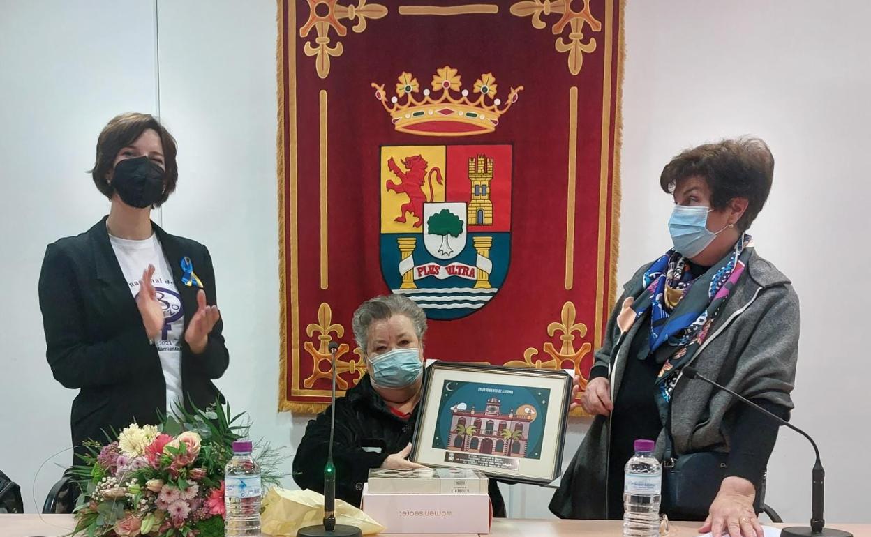Valentina del Barco sostiene una placa conmemorativa en el salón Juan Simeón Vidarte.