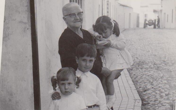 La Señá Julia con sus sobrinos nietos en la puerta de su casa,. 