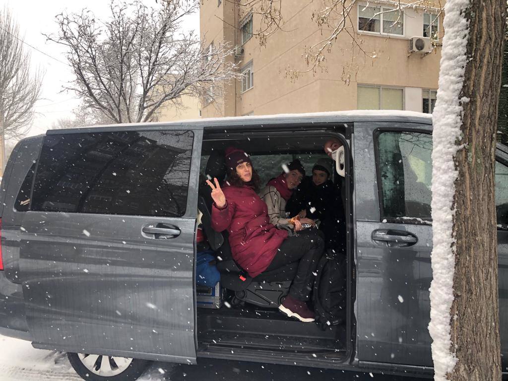 Los bailarines nos saludan dewsde el coche mientras nieva en Coslada 