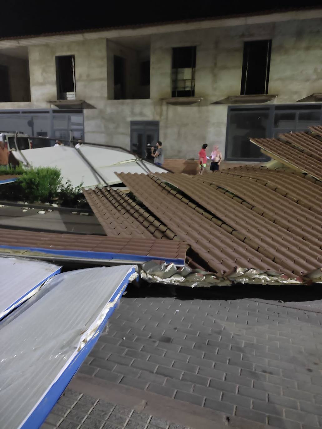 La cubierta en medio de la calle tras caeer del edificio que se ve al fondo. 