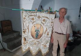 Rafael Santiago junto al estandarte de San rafael que aún conserva en su casa.