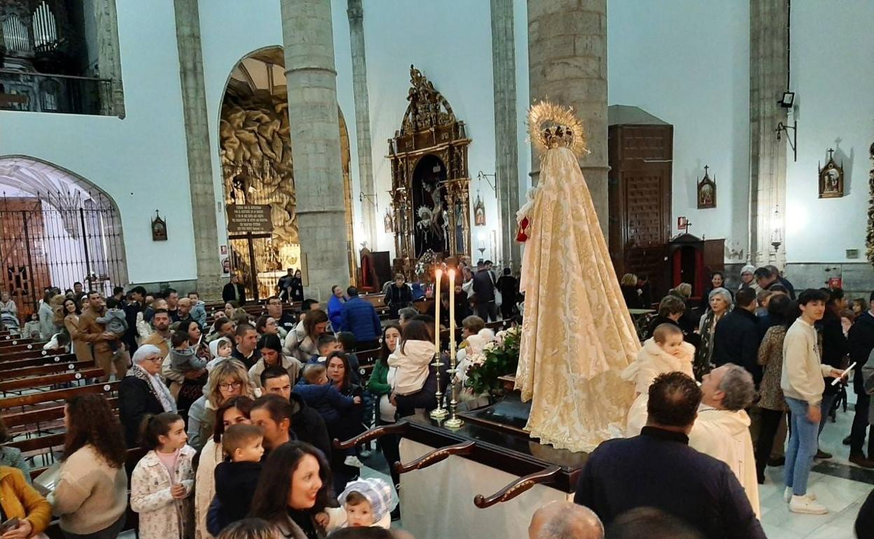 Momentoi en que el sacerdote pasa a un niño por el manto de la imagen 