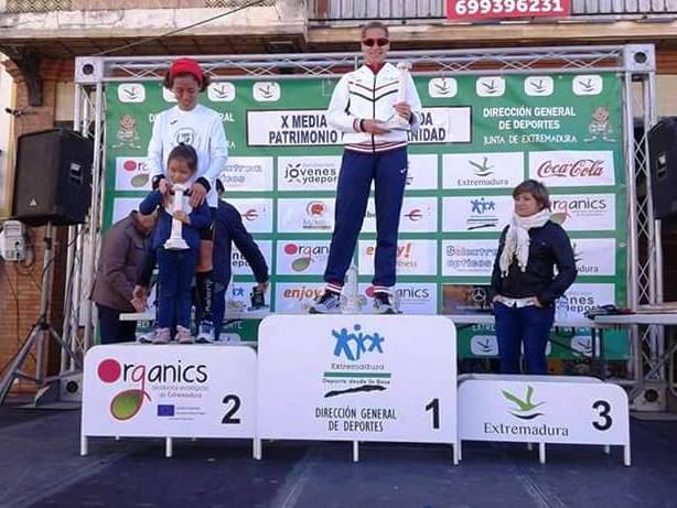 Sara Candelario en lo más alto del podium emeritens,e recibe el trofeo de manos de la judoka Conchi Bellorín, Directora General de Deportes de la Junta de Extremadura