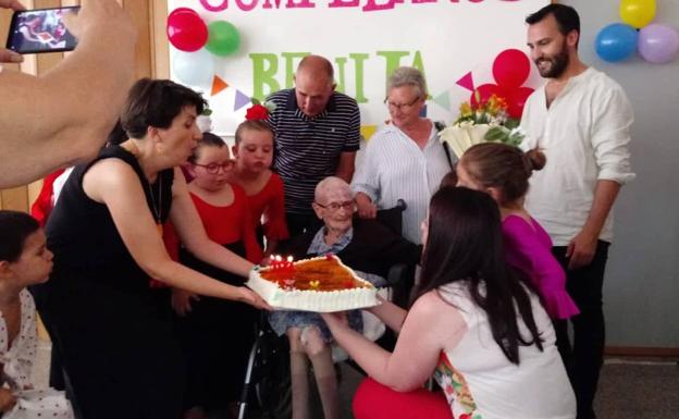 Imagen principal - Tras la entrega de regalos sopló las velas y comieron tarta y una pequeña merienda. 