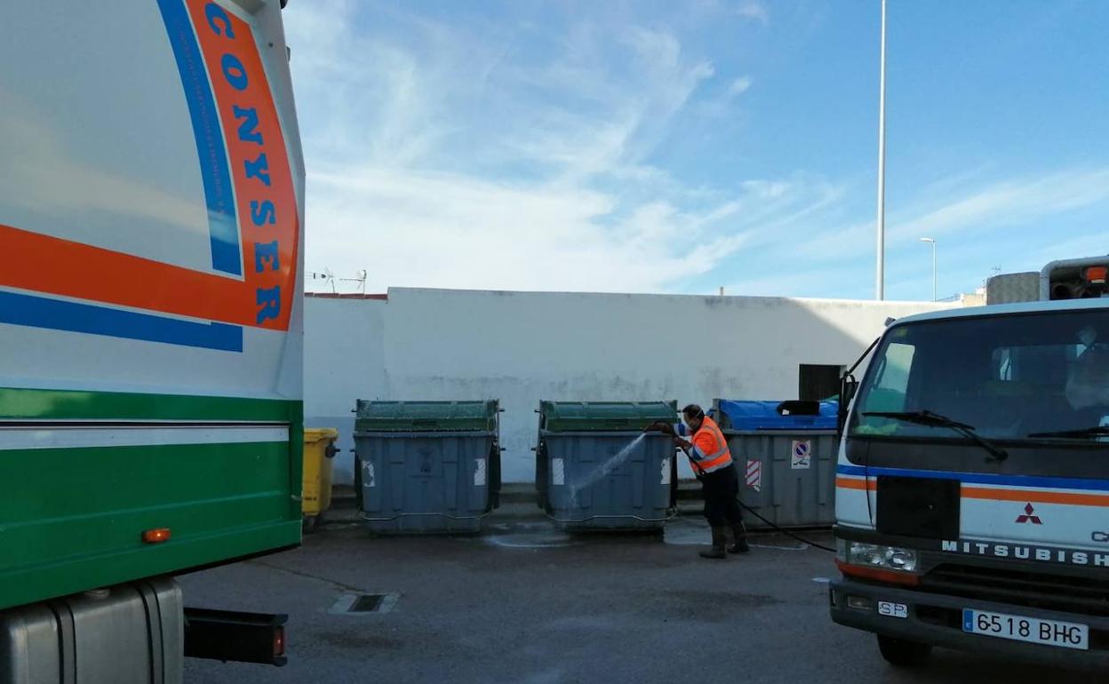 Un operario de Conyser desinfectando una de las paradas de contendores de basura. 